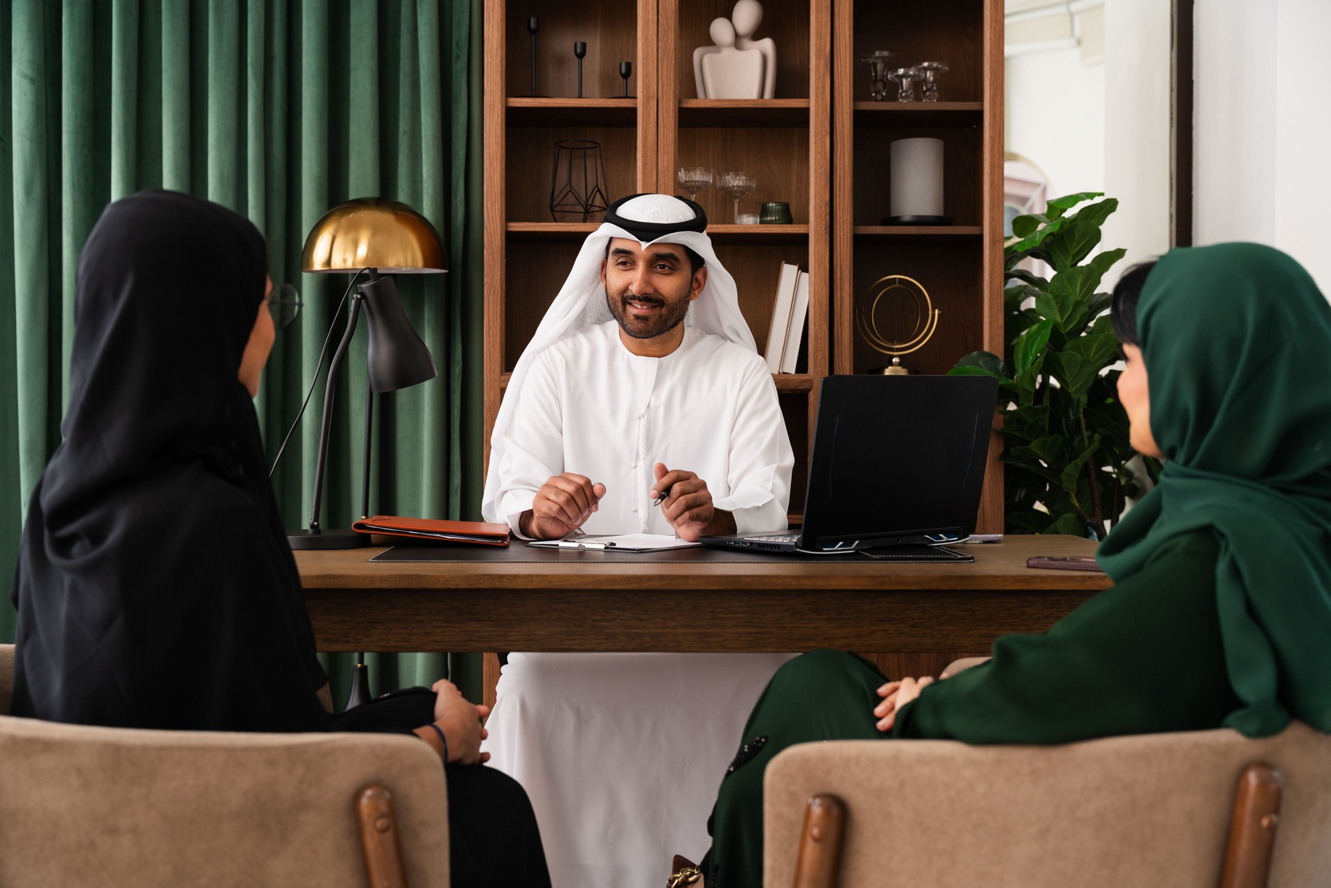 Emirati businessman advising clients in modern office