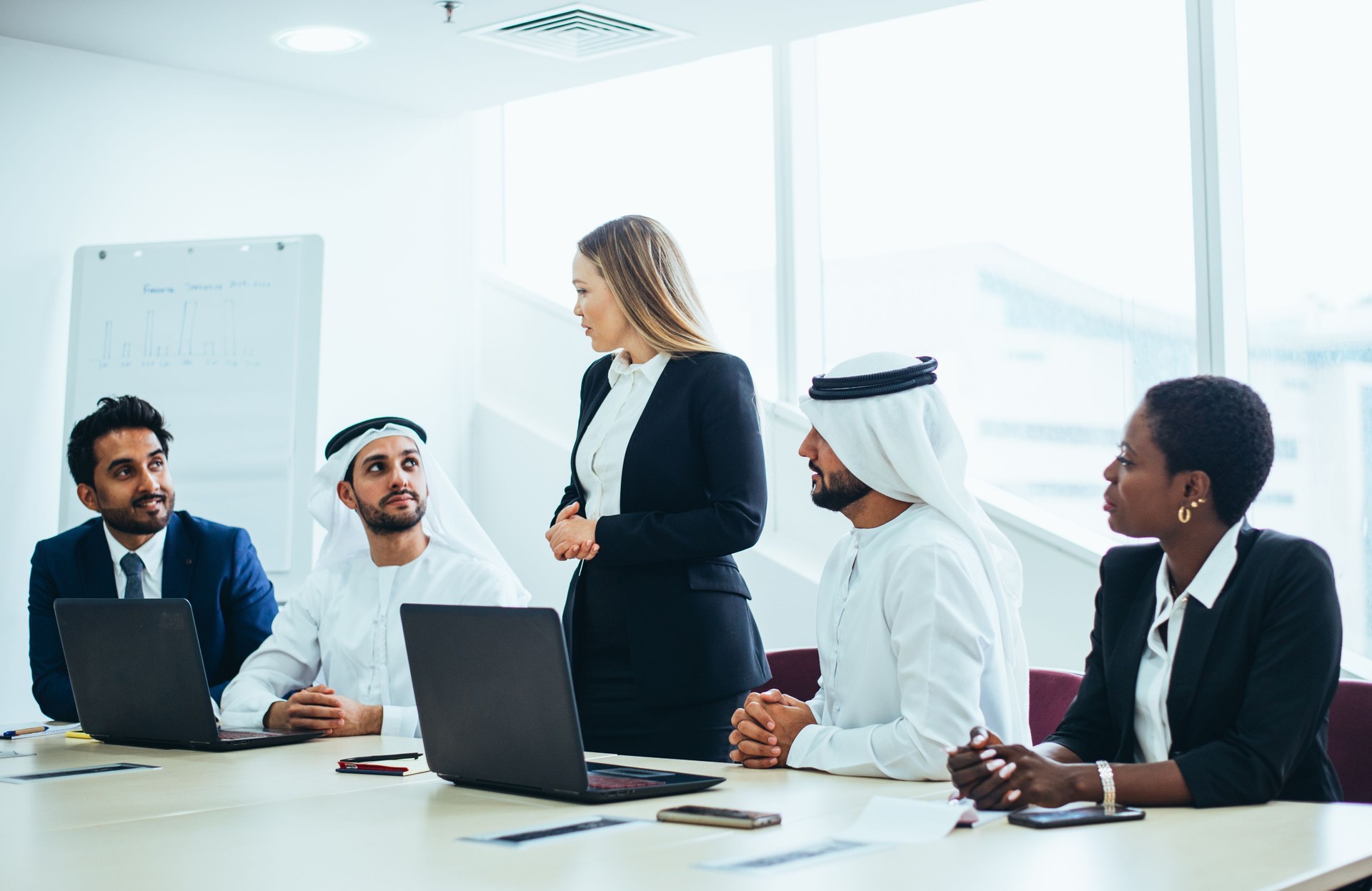 Multi-Ethnic Coworkers Discussing In Board Room At Office